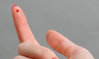female finger blood drop